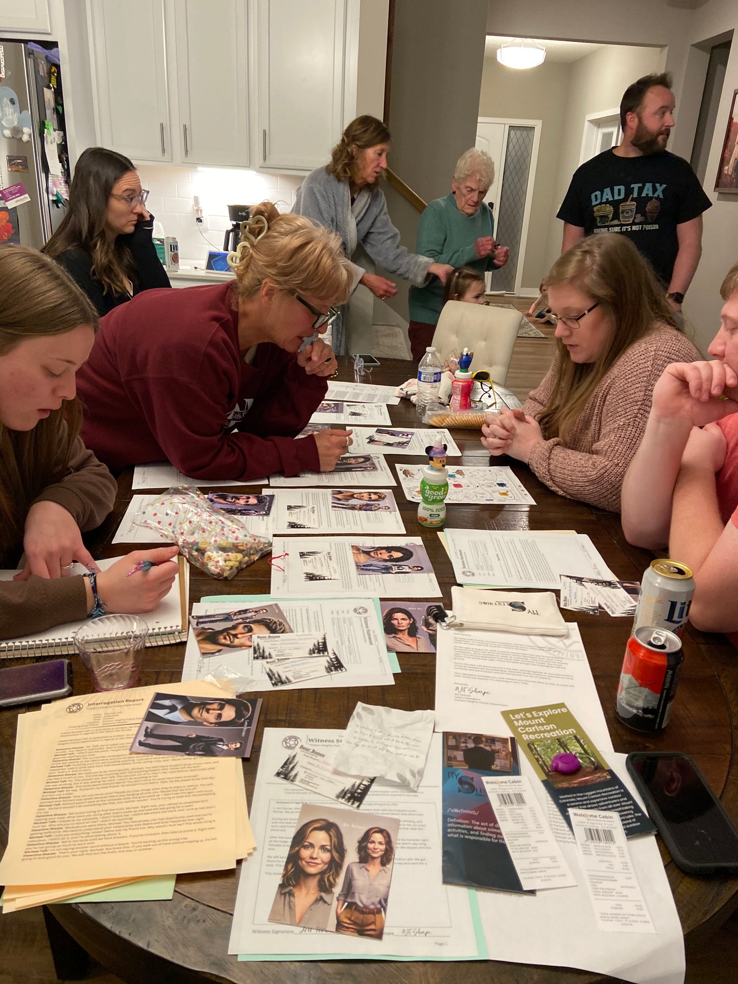 Group of people gathered around a table with evidence playing Murder mystery box game