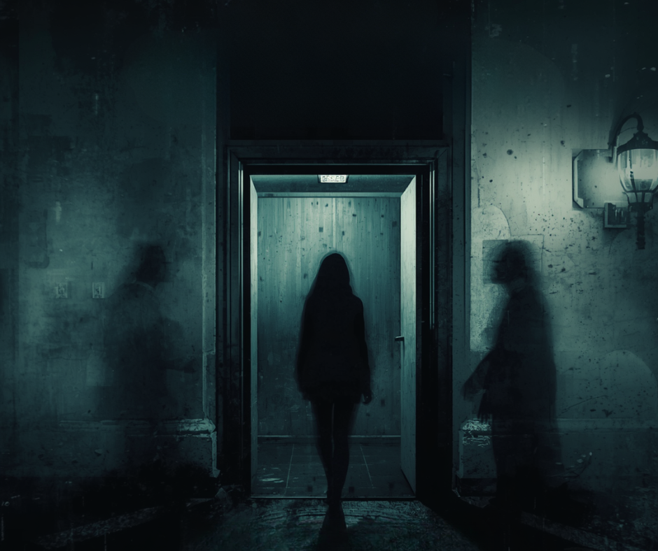 Silhouettes of people in a dimly lit room with an elevator