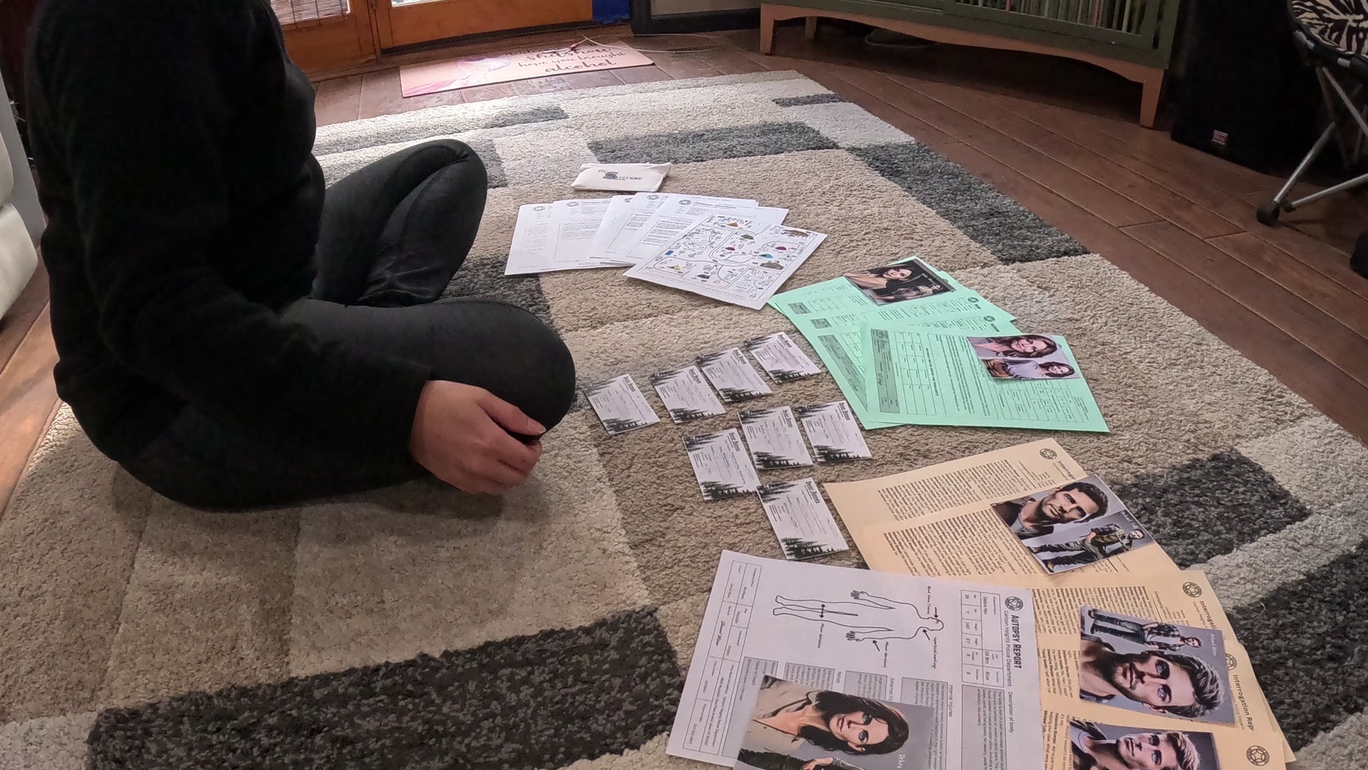 Video of person organizing Murder Mystery game box clues over the floor.